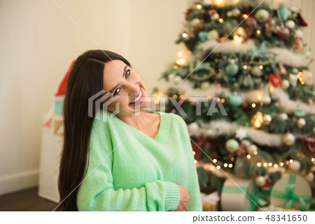 Holidays, celebration and people concept - young woman over christmas interior background. 48341650