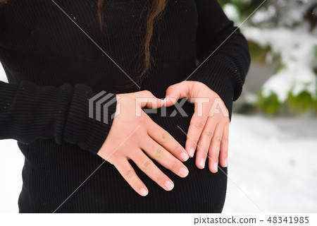 Detail of unrecognizable pregnant woman's belly in winter Detail of unrecognizable pregnant woman's belly in winter 48341985