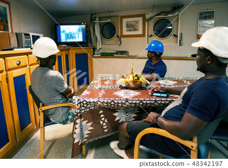 Seamen crew onboard a ship or vessel having fun watching TV Seamen crew onboard a ship or vessel having fun watching TV 48342197