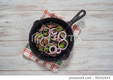 Beef pieces stewed on an old cast iron pan. 48342643