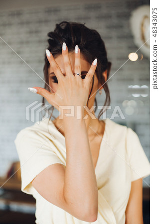 Brunette bride showing hand with wedding ring and Brunette bride showing hand with wedding ring and 48343075