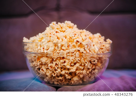Hot popcorn in a bowl on the couch. Hot popcorn in a bowl on the couch. 48343276