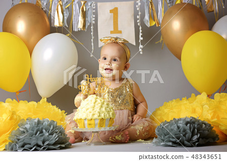 Little baby girl eating birthday cake during cake smash party 48343651