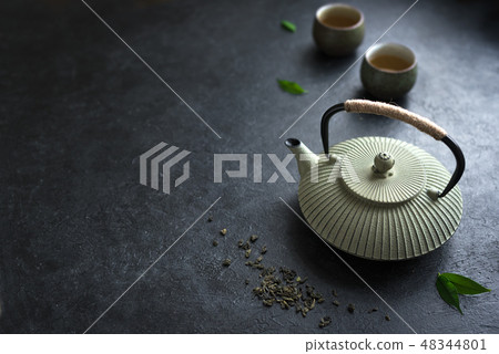 Teapot and teacups on black table 48344801