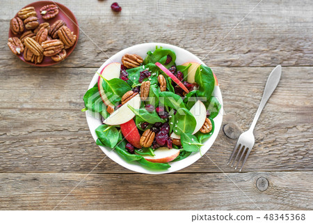 Spinach, apple salad with pecan nuts and cranberries 48345368
