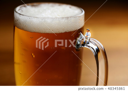 A man sitting on a beer mug 48345861