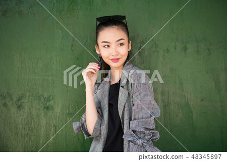 Cute exited Asian girl thinking and smiling Cute exited Asian girl thinking and smiling 48345897