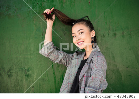 Beautiful asian woman having fun and hold her hair Beautiful asian woman having fun and hold her hair 48345902
