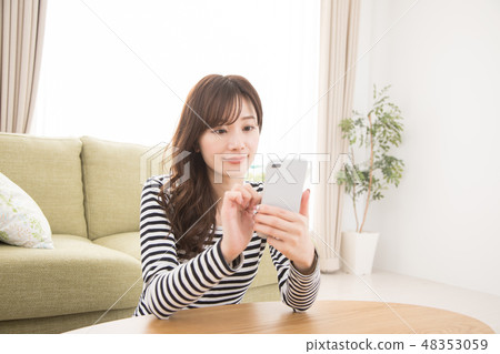 A woman using a smartphone A woman using a smartphone 48353059