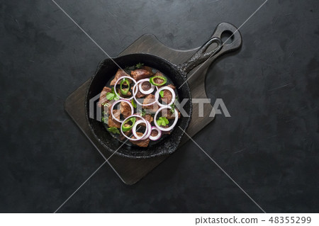 Pieces of roast beef in an old black pan. Pieces of roast beef in an old black pan. 48355299