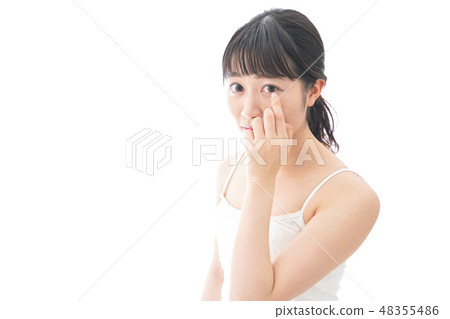 A young woman wearing a contact lens A young woman wearing a contact lens 48355486