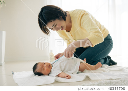 穿著內衣的年輕母親在嬰孩變動衣裳關心 48355708