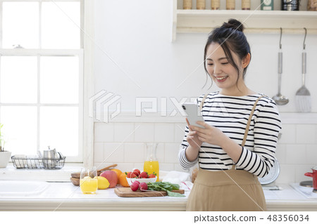 Female smartphone kitchen 48356034