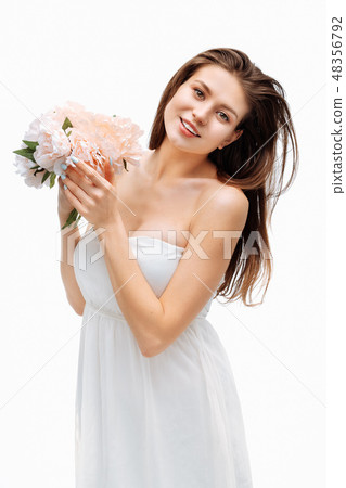 Portrait girl smiling and posing with artificial flowers on white background. Portrait girl smiling and posing with artificial flowers on white background. 48356792