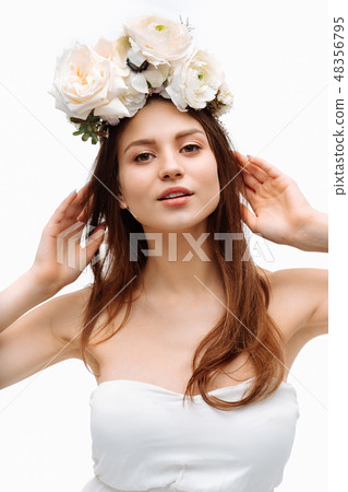 Beautiful young girl smiling and posing with flowers on white background. 48356795