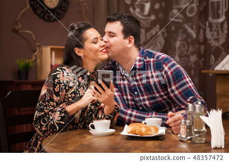 Young beautiful couple in restaurant showing affection. Young beautiful couple in restaurant showing affection. 48357472