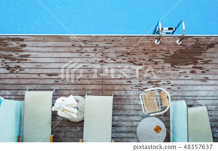 A top view of sunbathing deck and private swimming pool near beach, summer holiday concept. A top view of sunbathing deck and private swimming pool near beach, summer holiday concept. 48357637