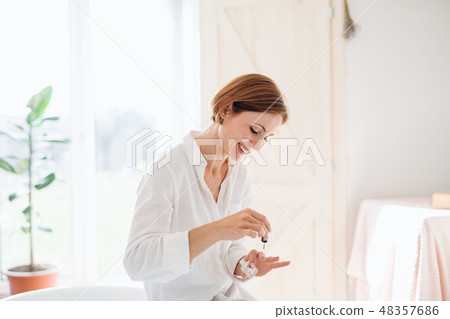 A young woman in the morning in a bathroom, applying nail polish. 48357686