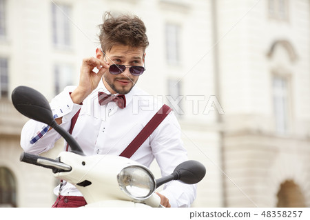 Hipster fashion men with scooter on a sunny day in the city Hipster fashion men with scooter on a sunny day in the city 48358257
