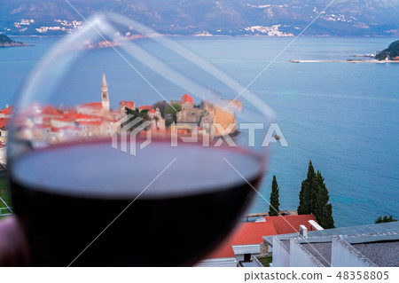 Glass with red wine above Budva Glass with red wine above Budva 48358805