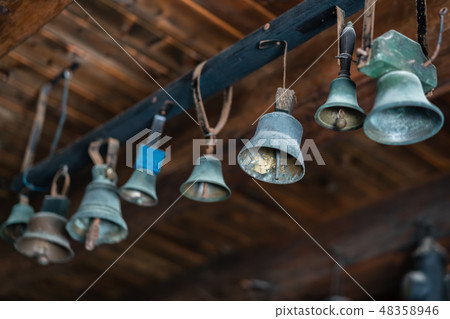 Small brass bells hanging in the cellar Small brass bells hanging in the cellar 48358946