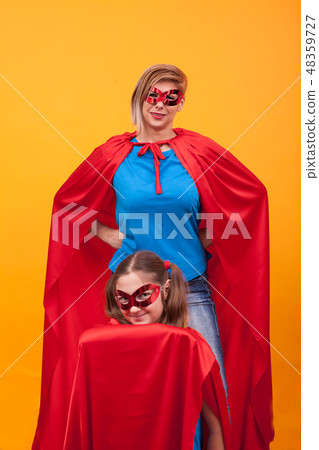Mother and daughter playing together dressed like superheros 48359727
