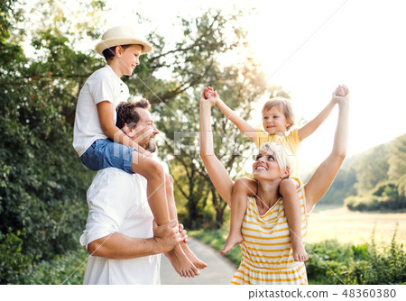 Young family with small children in sunny summer nature. 48360380