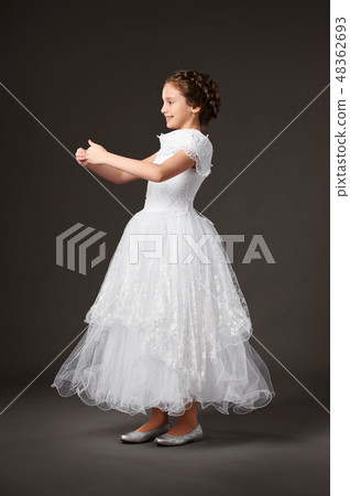 little girl is in white ball gown, dark background little girl is in white ball gown, dark background 48362693
