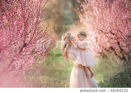 Mom with an infant in the rose garden with flowers trees 48364220