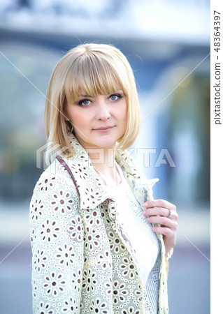 Autumn fashionable image of cute young woman with short hairs and candid smile. Trendy coat, denim Autumn fashionable image of cute young woman with short hairs and candid smile. Trendy coat, denim 48364397