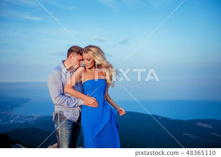 Beautiful couple of newlywed hugging at wedding day on cliff with ocean view. Stylish bride and 48365110