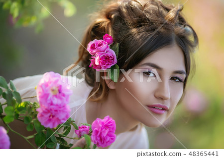 Portrait of a girl with make-up. With flowers in her hair. Beautiful face. Portrait of a girl with make-up. With flowers in her hair. Beautiful face. 48365441