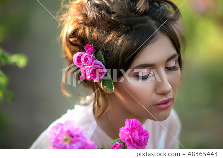 Portrait of a girl with make-up. With flowers in her hair. Beautiful face. Portrait of a girl with make-up. With flowers in her hair. Beautiful face. 48365443