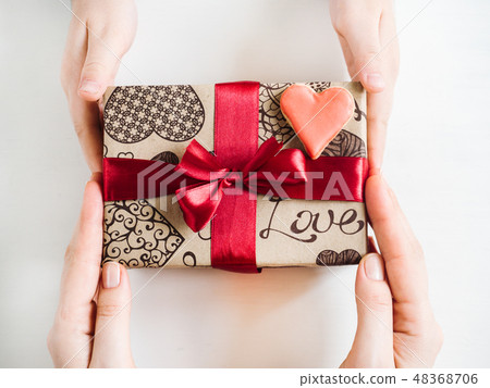 Hands of a parent and a child, box with a gift 48368706