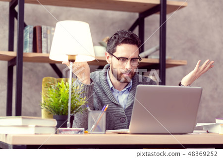 Serious handsome man standing with a book 48369252