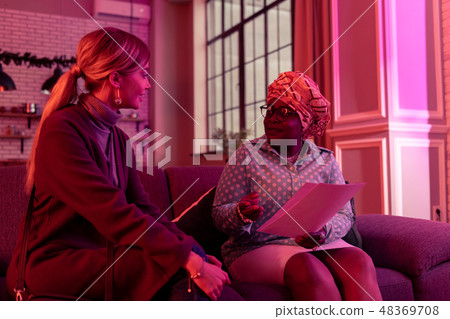 Cute long-haired young woman with long earrings talking to the fortune-teller Cute long-haired young woman with long earrings talking to the fortune-teller 48369708