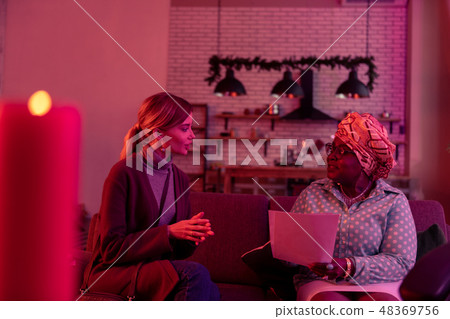 Cute long-haired young woman with long earrings looking involved Cute long-haired young woman with long earrings looking involved 48369756