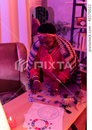 African american plump fortune-teller with huge earrings reading Tarot cards 48370022