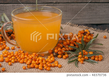 Sea buckthorn tea with a sprig on sackcloth Sea buckthorn tea with a sprig on sackcloth 48370736