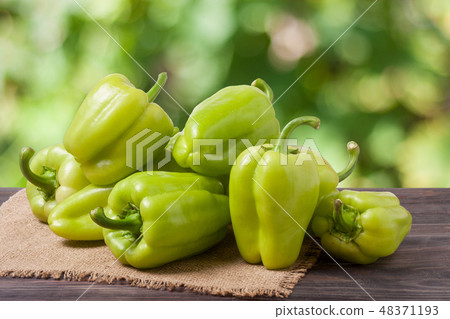 pile green pepper on a wooden table with blurred background 48371193