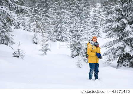 The photographer in winter forest in mountains 48371420