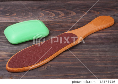 double-sided grater for feet with soap on a wooden background double-sided grater for feet with soap on a wooden background 48371536
