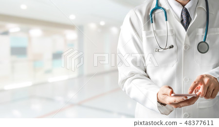 Male doctor using mobile phone at hospital. Male doctor using mobile phone at hospital. 48377611
