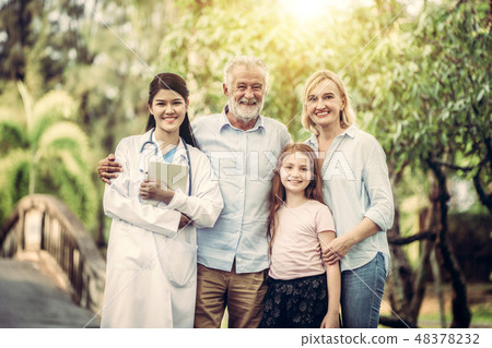 Happy healthy family and doctor talking in park. Happy healthy family and doctor talking in park. 48378232