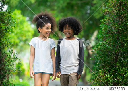 Happy little boy and girl in the park. Happy little boy and girl in the park. 48378363