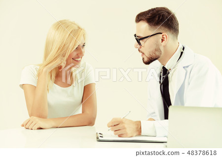 Male Doctor and Female Patient in Hospital Office 48378618
