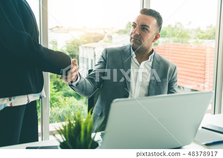 Businessman handshake businesswoman in office. Businessman handshake businesswoman in office. 48378917