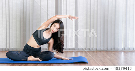 Young woman practice yoga in an gym studio. Young woman practice yoga in an gym studio. 48379413
