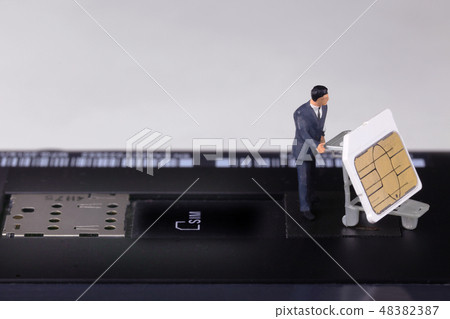 A man who pulls out a SIM card from a smart phone 48382387