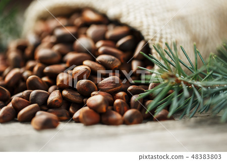 Pine nuts in a bag of burlap on an old vintage Pine nuts in a bag of burlap on an old vintage 48383803